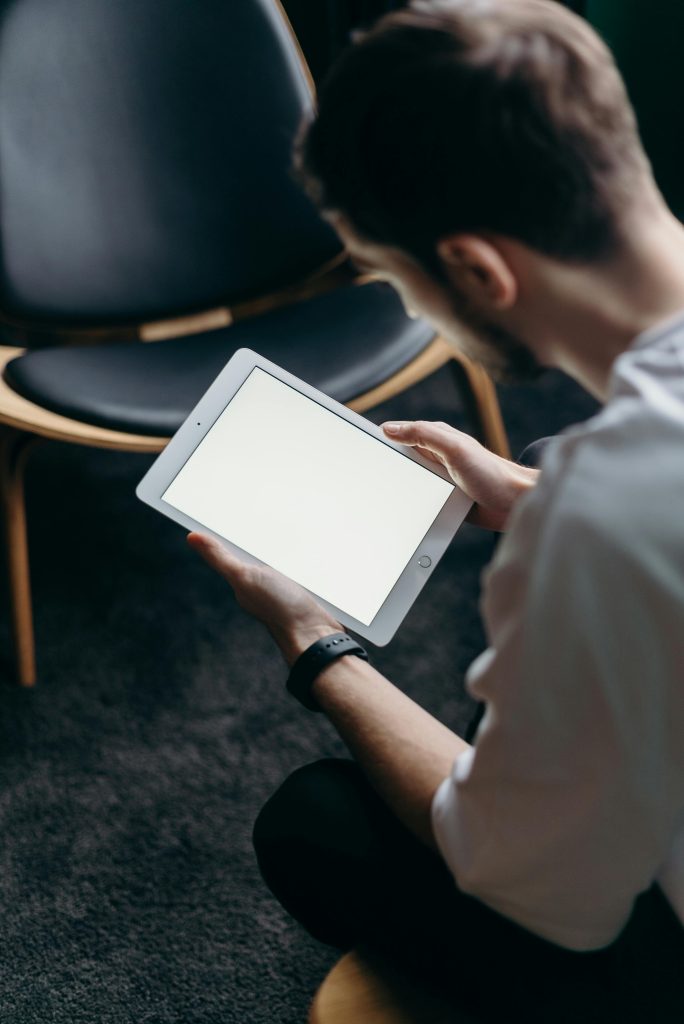 Man in White Shirt Holding White Tablet Computer